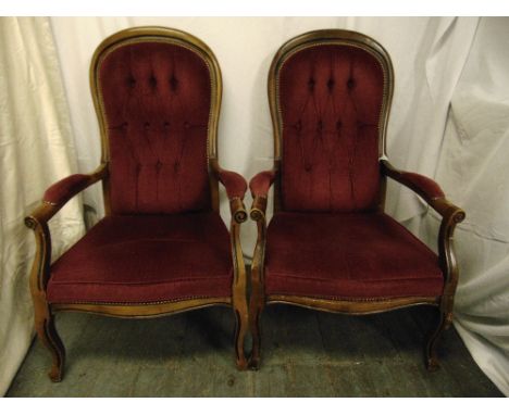 A pair of mahogany button back upholstered armchairs on scroll legs
