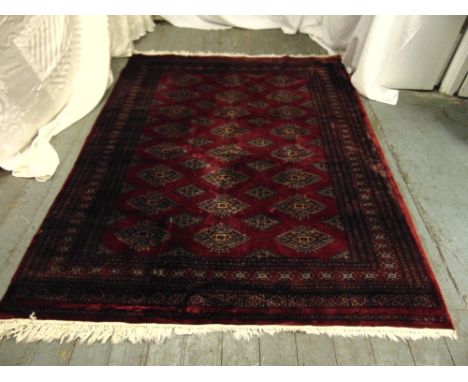 A Persian wool carpet red ground with geometric patterns and border, 231 x 176cm