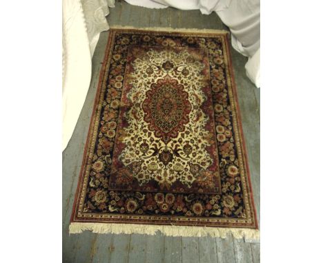 A Persian silk and wool carpet, red and green ground with birds flowers and repeating patterns within a royal blue border, 22