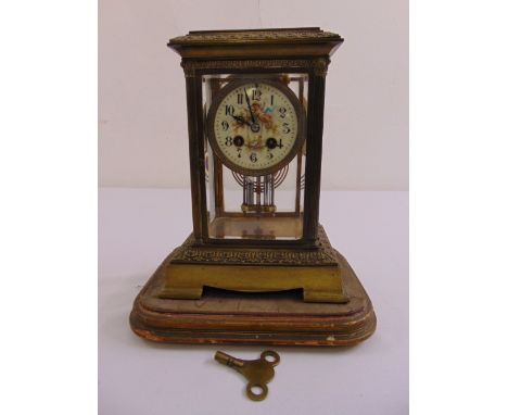 A rectangular brass and glass cased mantle clock, painted enamel dial with Arabic numerals, to include mercury pendulum and k