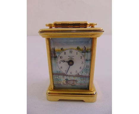 A Halcyon Days miniature brass and enamel carriage clock depicting a river scene, to include key