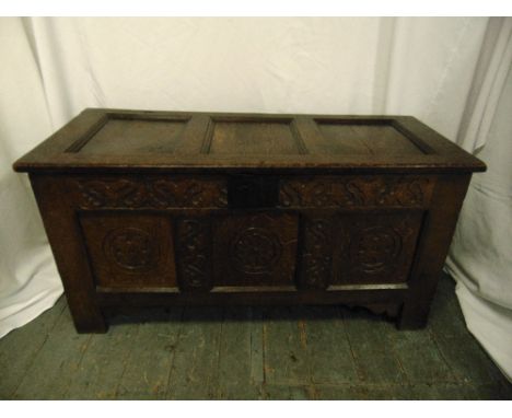 An early rectangular oak coffer with carved side panels, hinged cover and bracket feet