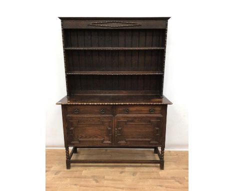 1920's oak two height dresser with shelves above, two drawers and two geometric panelled doors below on bobbin turned legs jo