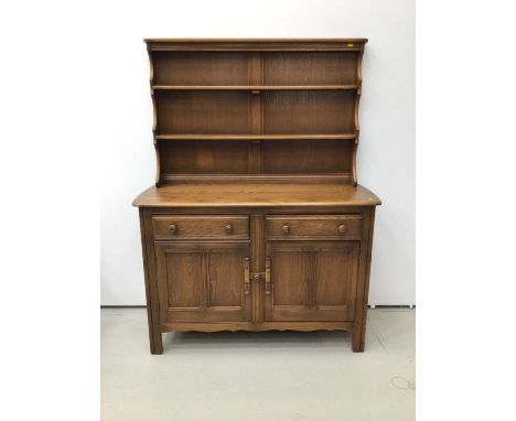 Ercol elm two height dresser, with shelved rack, the base with two drawers over twin cupboards, 124cm wide x 46cm deep x 146c