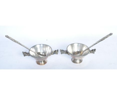 A pair of 20th century Chinese silver plate eating bowls with accompanying spoons. The bowls having twin handles modelled in 