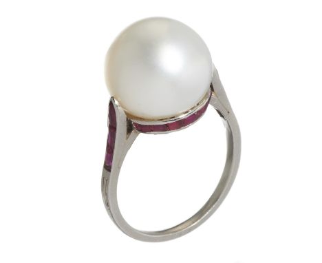 A RUBY AND CULTURED PEARL RING  the 1.1cm cultured pearl set in a girdle of calibre cut rubies between conforming shoulders, 