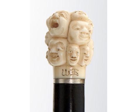 AN EBONY CANE WITH JAPANESE IVORY POMMEL, MEIJI PERIOD  the pommel carved with masks, ivory 4.5cmh, 81.5cm overall, ivory sig