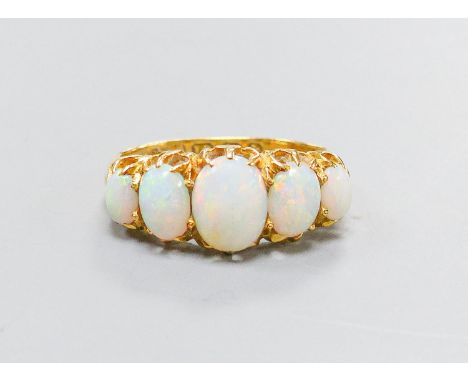 An Edwardian 18ct gold and graduated five stone white opal set half hoop ring, size K, gross 3.8 grams.