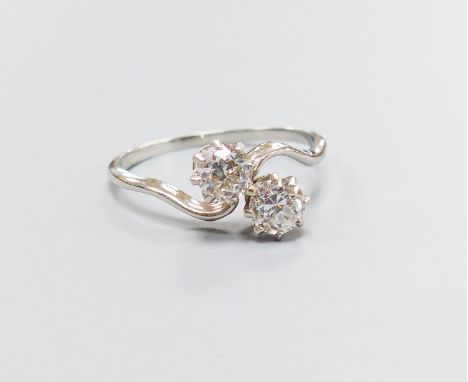 A white metal and two stone diamond set crossover ring, size K, gross 2.4 grams,each stone weighing approx. 0.18-0.20ct.