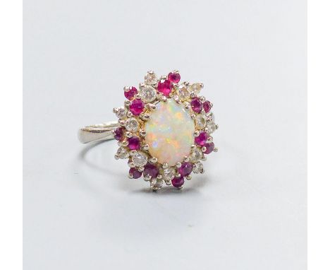 An 18ct white metal, white opal, ruby and diamond set oval cluster ring, size N, gross weight 6.1 grams.