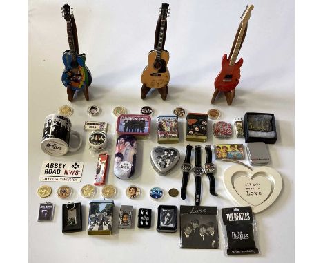 A quantity of Beatles collectables to include: three painted miniature guitars with fold out wooden stands, thirteen coins in