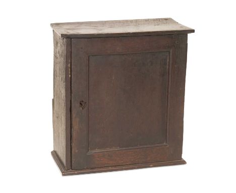 A SMALL OAK CUPBOARD, 17TH/18TH CENTURY with panel door and shelved interior. 44cm high, 41cm wide, 21cm deep