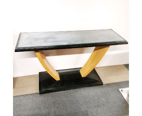 A black finished and light wood veneered Art Deco style sideboard with plate glass protective top, 138 x 78 x 45cm.