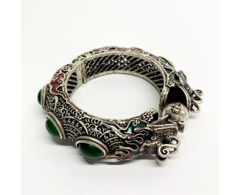 A heavy Chinese enamelled and stone set white metal hinged bangle, internal dia. 6cm, bangle W. 2cm.