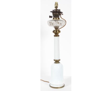 A gilt metal and milk glass oil lamp with a clear glass reservoir on a mallet form body, converted for electricity, 77cm high