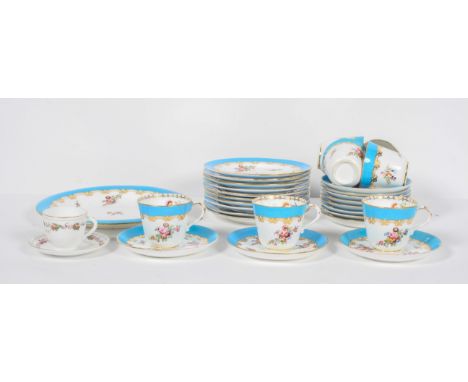 An English porcelain tea set late 19th century, painted with flowers beneath a blue and gilt rim, comprising seven cups and e