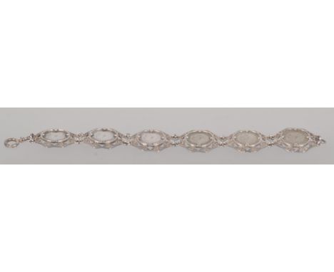 A white metal abstract linked bracelet, each set with a  threepenny bit dating from 1917 to 1921. 8 inch length; bolt ring cl