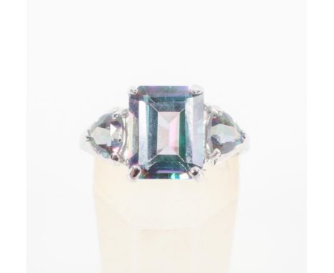 A white metal three stone ring set with rectangular and trilliant cut coated topaz. Hallmarked 9ct gold, Birmingham. Stamped 