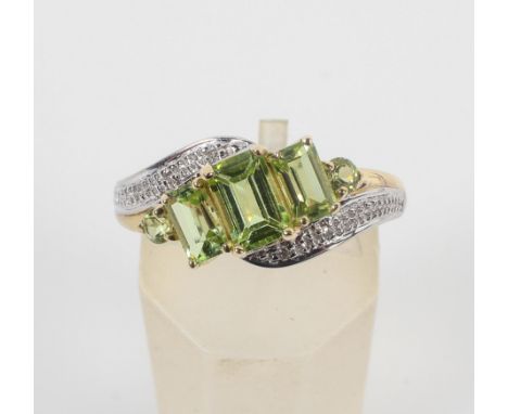 A yellow metal ring set with rectangular/round cut peridot and finished with illusion set diamond shoulders. No hallmark - st