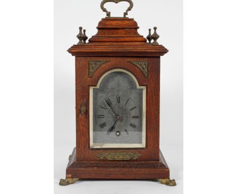 An oak cased mantel time piece, the metal dial with chapter ring on a brass movement, stamped Lenzkirch, the case with caddy 