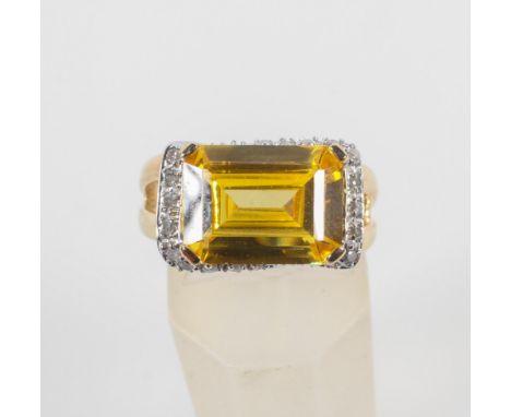 A yellow metal ring. Principally set with a rectangular cut yellow quartz and finished with diamonds. No hallmark - stamped 9