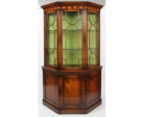 A reproduction George III style mahogany glazed display cabinet, of canted D-section, with geometric astragals enclosing two 