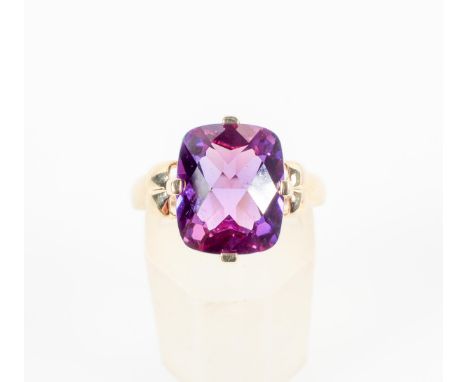 A yellow metal single stone ring set with a cushion faceted chequerboard cut amethyst. No hallmark - Stamped 10K SLV. Size: M