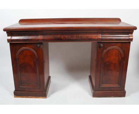 A Victorian mahogany sideboard, with three cushion shaped frieze drawers, with short gallery back, with two cupboard supports