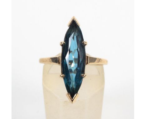 A yellow metal single stone ring. Set with a marquise cut synthetic blue spinel. No hallmark - stamped 10K. Size: L 3.4 grams