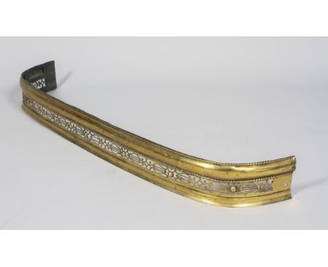 A Victorian brass fire fender, late 19th century, cast as pierced interlocking lyre motifs alternating with domed bosses, abo