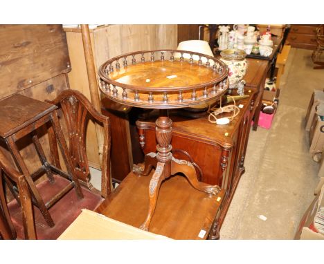 A circular topped table raised on tripod base