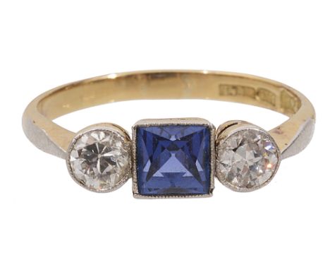 A sapphire and diamond-set three stone ringthe square-cut sapphire flanked to either side by a brilliant-cut diamond, the pla