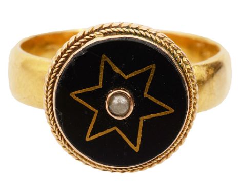 A late Victorian black onyx, seed pearl and gold ring, the circular onyx plaque decorated with a yellow gold wirework star mo