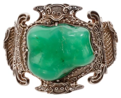 An impressive Chinese filigree and green hardstone flexible hinged bangle, the large central green tumbled hardstone to the o