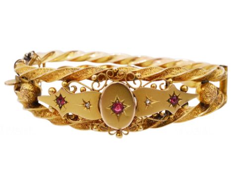A Victorian 9ct gold Etruscan style ruby and diamond set banglethe hinged bangle of open engraved twist design with threadwor