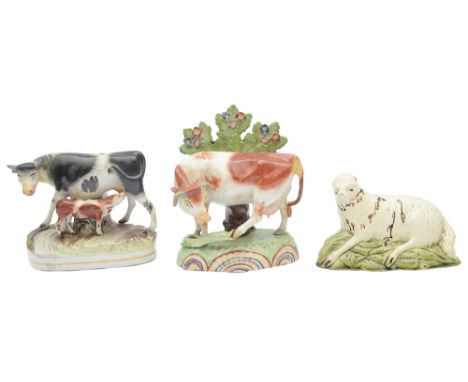 An early 19th century Staffordshire pearlware cow group in the manner of Obadiah Sheratt, a pearlware hollow cast recumbent s
