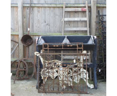 An ornate iron gate, 113 x 82cm, together with another, a pair of bench ends, a grain hopper, a set of wooden steps, a smelti
