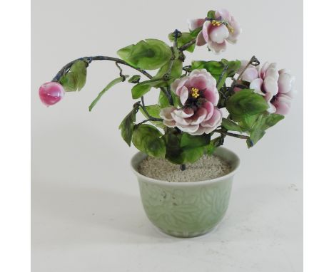 A jade coloured carving of a tree in a celadon glazed pot, 21cm high