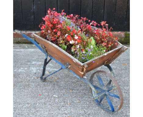 A vintage wooden wheelbarrow, planted with flowers, 124cm long overall