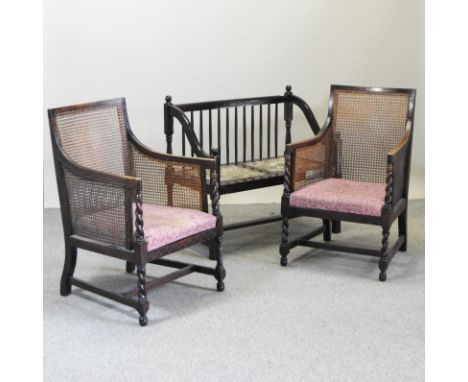 A pair of 1920's oak single cane bergere armchairs, together with an oak stick back hall seat 