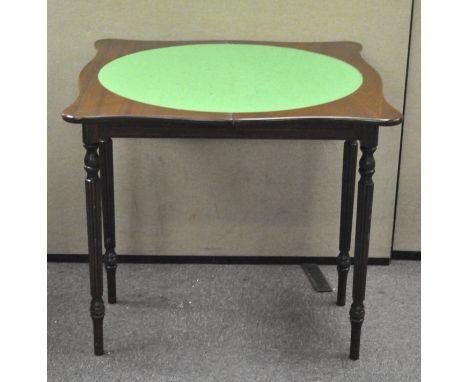 A mahogany shaped square card table, the revolving top inset with green baize and enclosing various games, height 78cm x widt