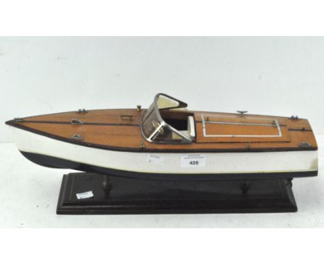 A scratch built model speedboat, wood with small metal fittings, mounted on a rectangular wooden plinth, length 49cm