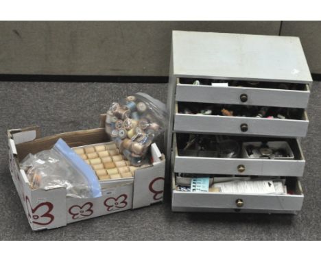 A small wooden six drawer sewing cabinet, painted light blue and containing a large quantity of buttons, needles and fastenin