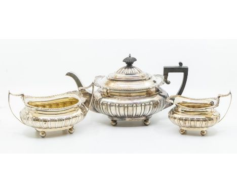 An Edwardian three piece silver tea set including teapot, sugar bowl, cream jug, shell and scroll decoration,&nbsp;by James D