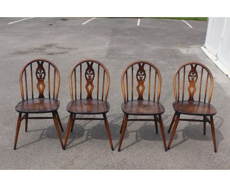 An Ercol set of four Fleur De Lys beech and elm seated dining chairs (4)