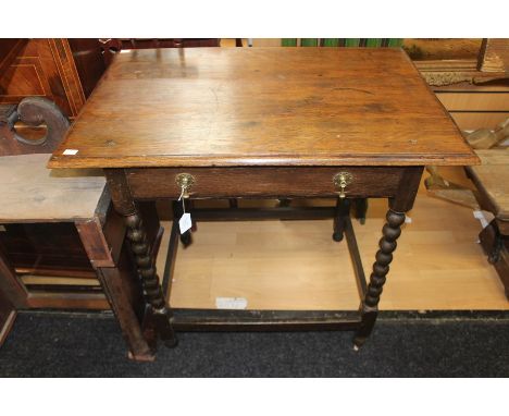 A Victorian joined oak side table, with an overhanging top, single drawer, elm linings, raised on bobbin turned legs. 73cm H 