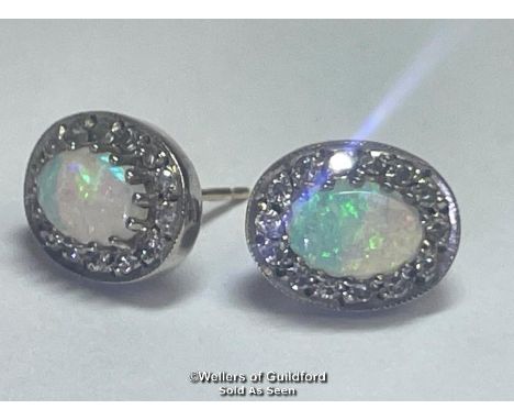 A pair of oval opal and diamond cluster earings in hallmarked 9ct gold. Opals measure approx 7mm x 5mm each surrounded by fou