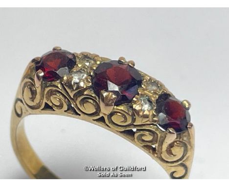 Garnet three stone carved style ring in 9ct gold, with white paste points. Hallmarked for Birmingham 1990, ring size Q, weigh