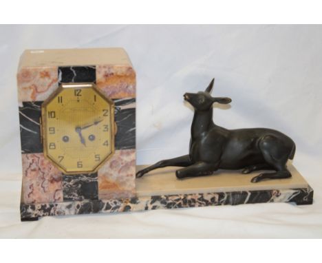 A French Art Deco mantel clock with gilt octagonal dial marked "Tonnelier Laval" in black and pink marble angular case flanke