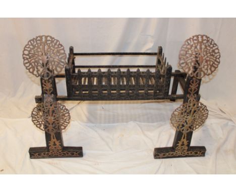 An unusual Arts &amp; Crafts brass mounted iron fire grate with rectangular basket, the supporting dogs with brass pierced ci